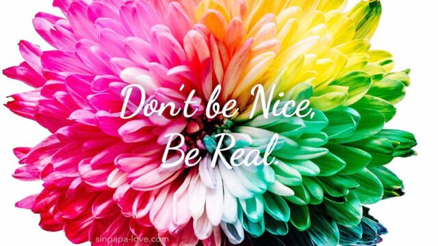 カラフルな色の花のアップショット写真。「Don't be Nice, Be real. 」の文字