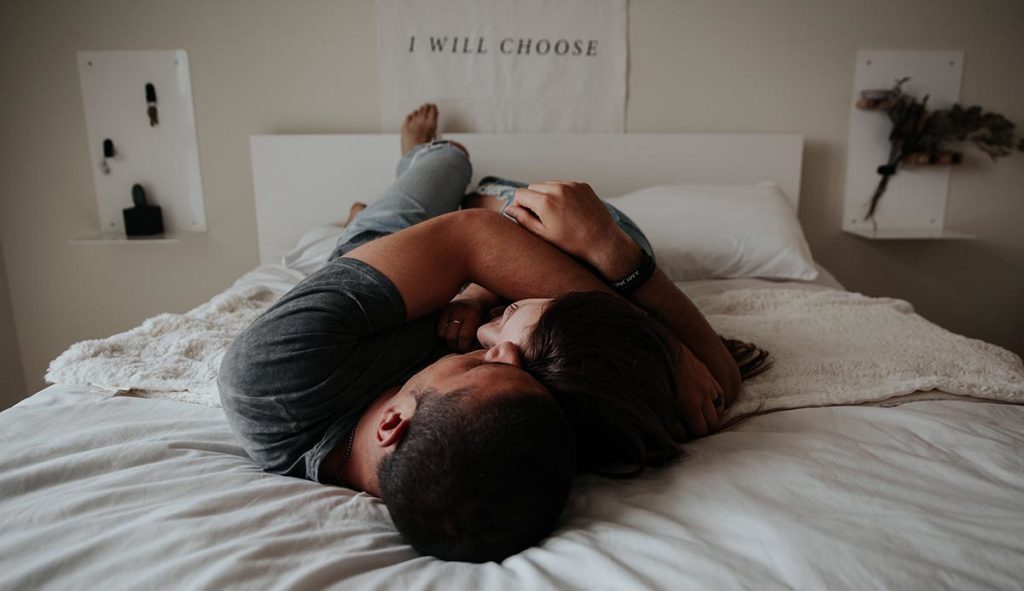 ベッドで抱き合うカップルの写真